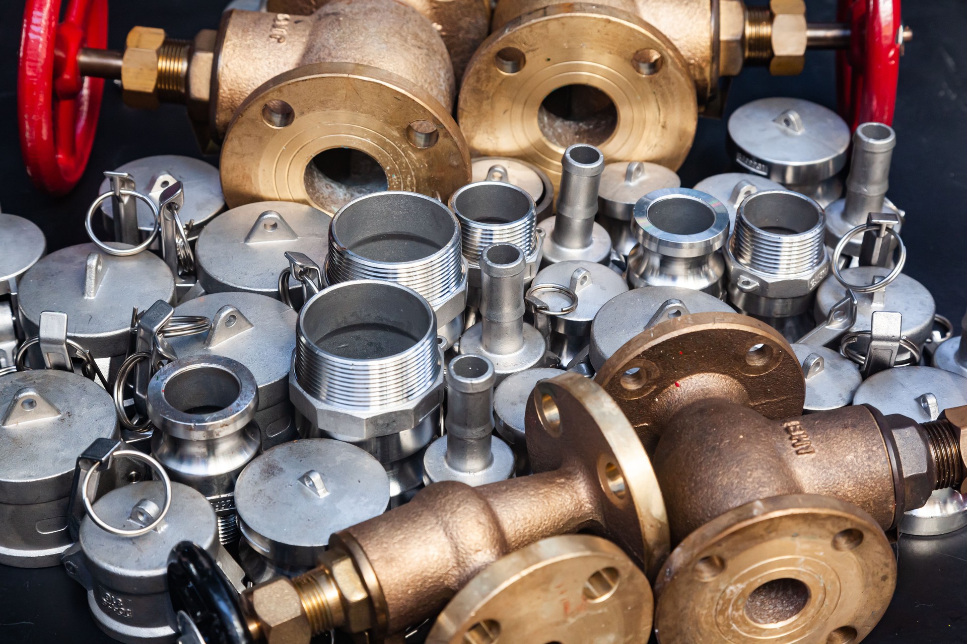 New bronze valves, stainless steel bushings, couplings and threaded connections. Plumbing details on a black background.